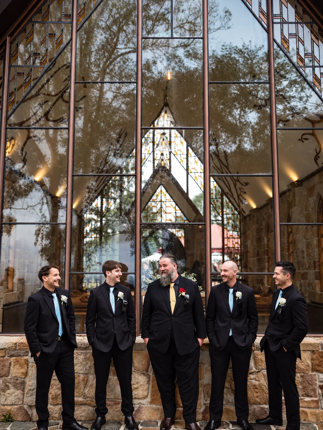 Bradley and his groomsmen outside the glass and stone Chapel