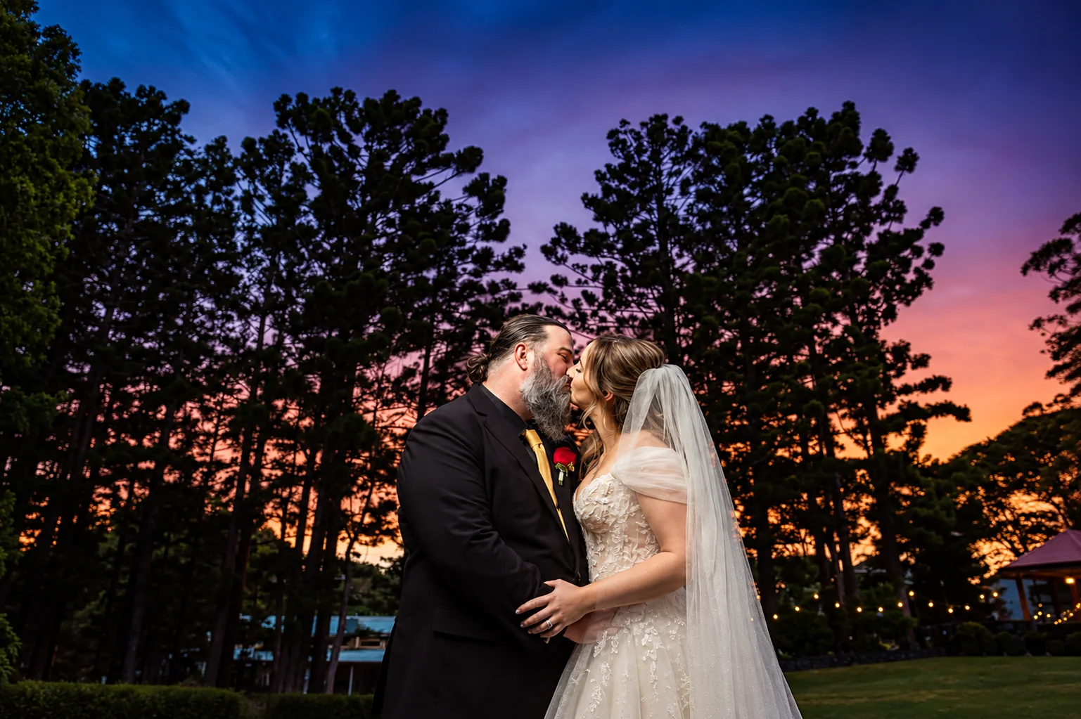Tricia and Bradley sharing a kiss beneath a colourful Montville sunset